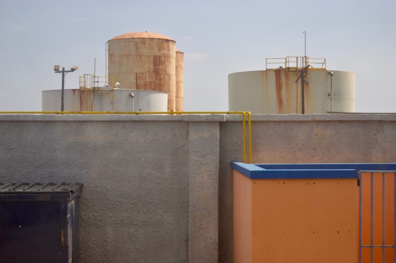 Oil tanks beyond a wall in San Nicolas, Aruba.